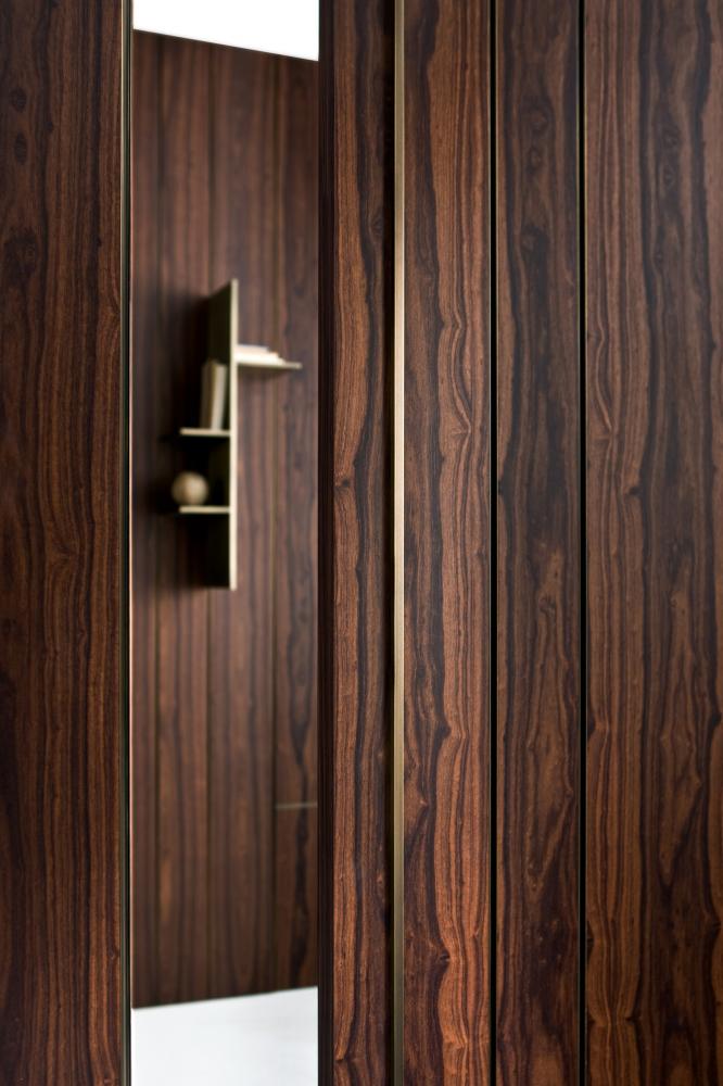 laurameroni wall panels and sliding door line in rosewood and brass details