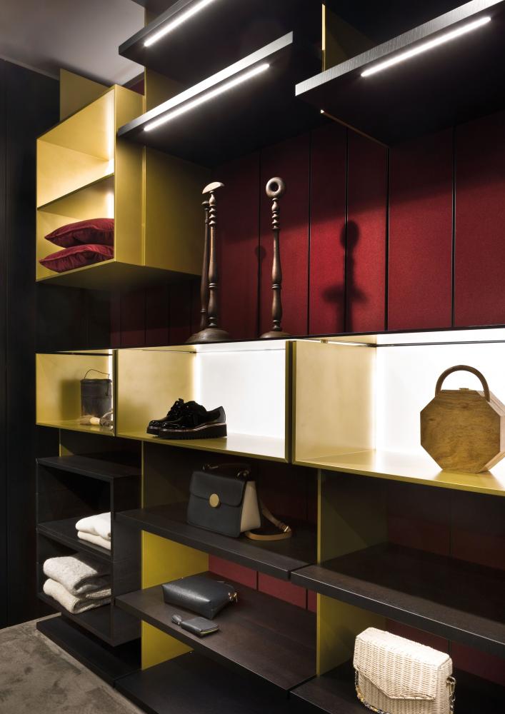 laurameroni line walk-in closet with wood panels covered in red liquid velvet