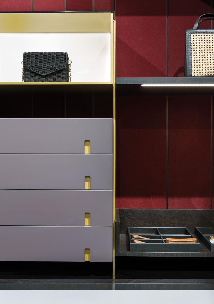 laurameroni line walk-in closet with wood panels covered in red liquid velvet