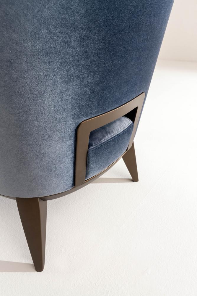 Margaret is a modern armchair in leather, velvet or fabric with wooden handle