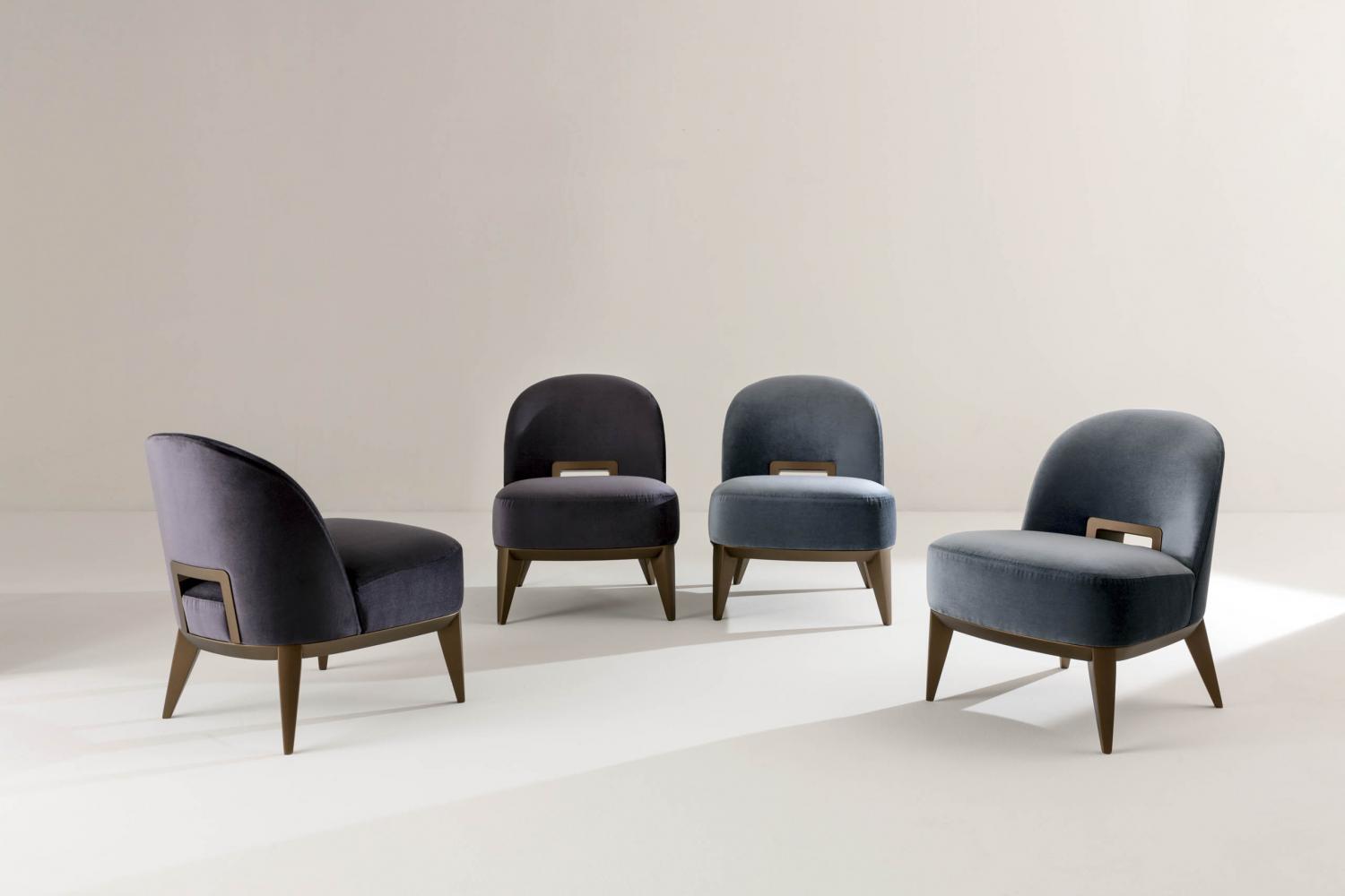 Margaret is a modern armchair in leather, velvet or fabric with wooden handle