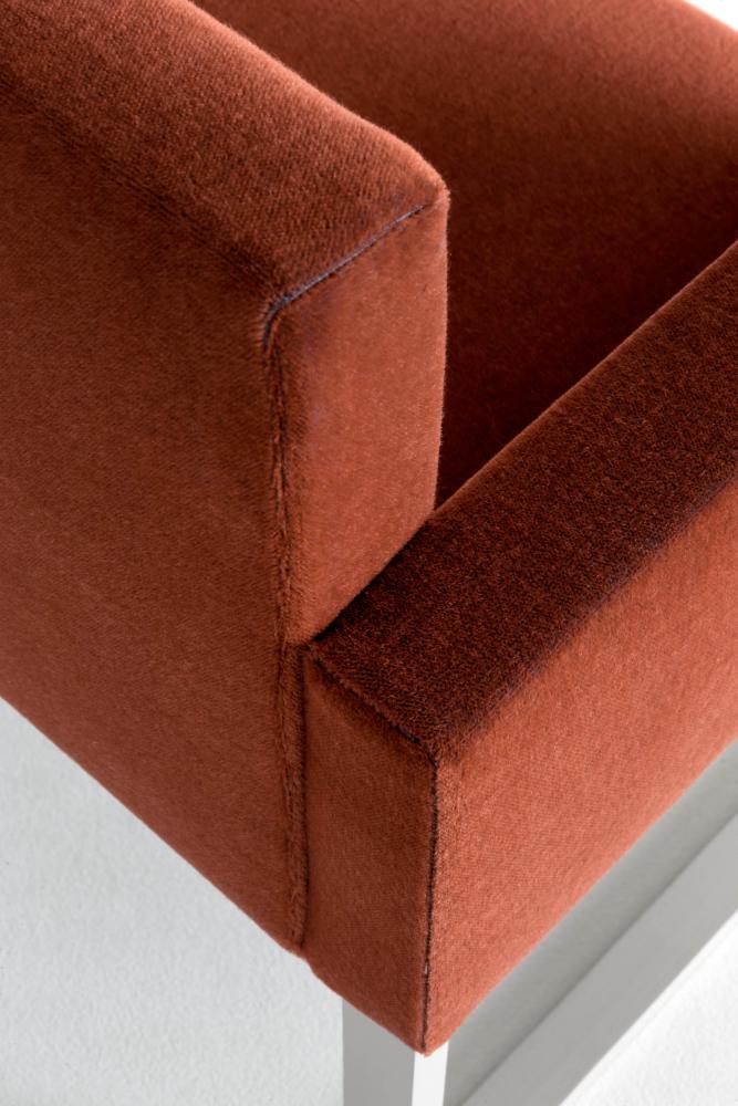 Modern padded armchair in leather fabric or velvet